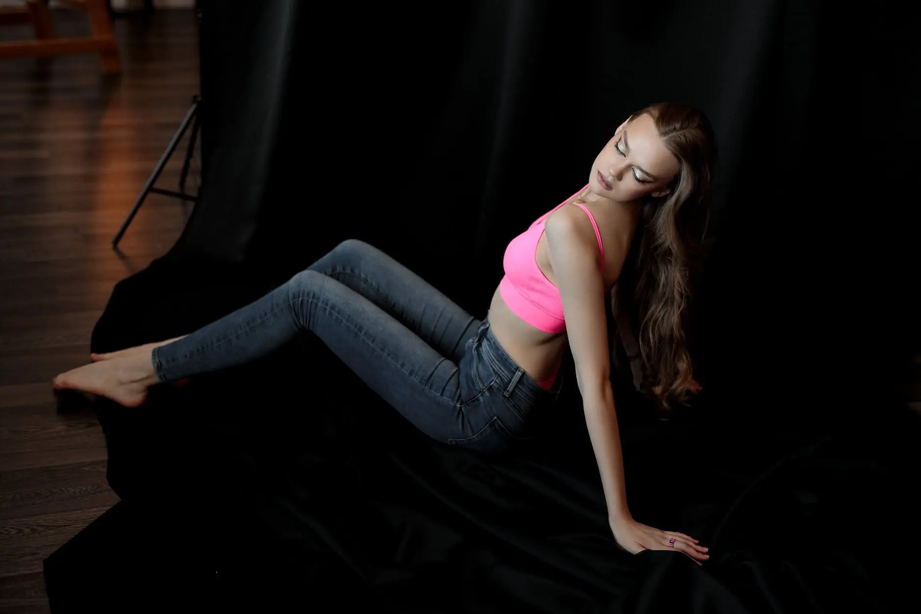 studio shot of a young woman in a pink top and jeans