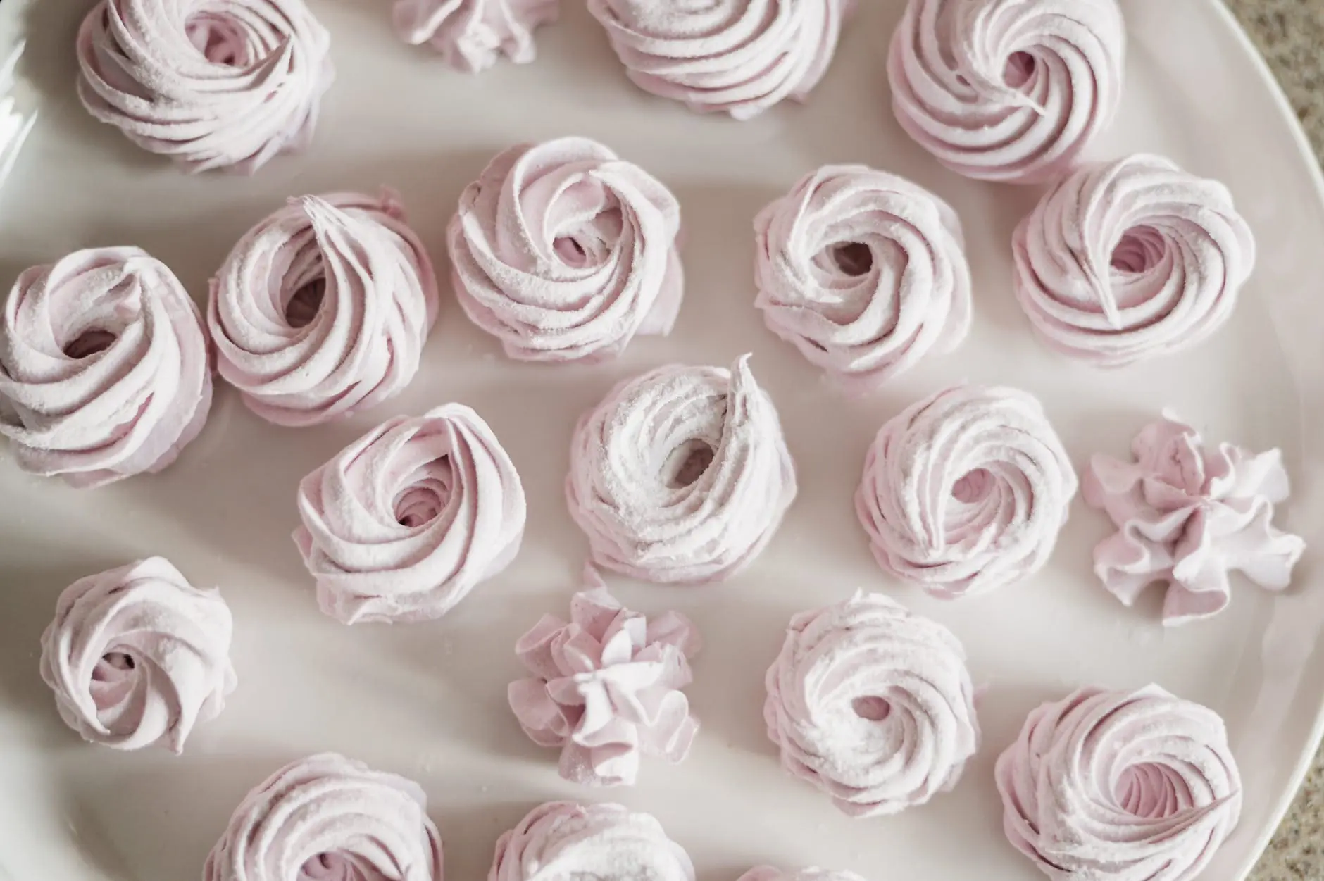pink meringues on a white plate from this meringue recipe