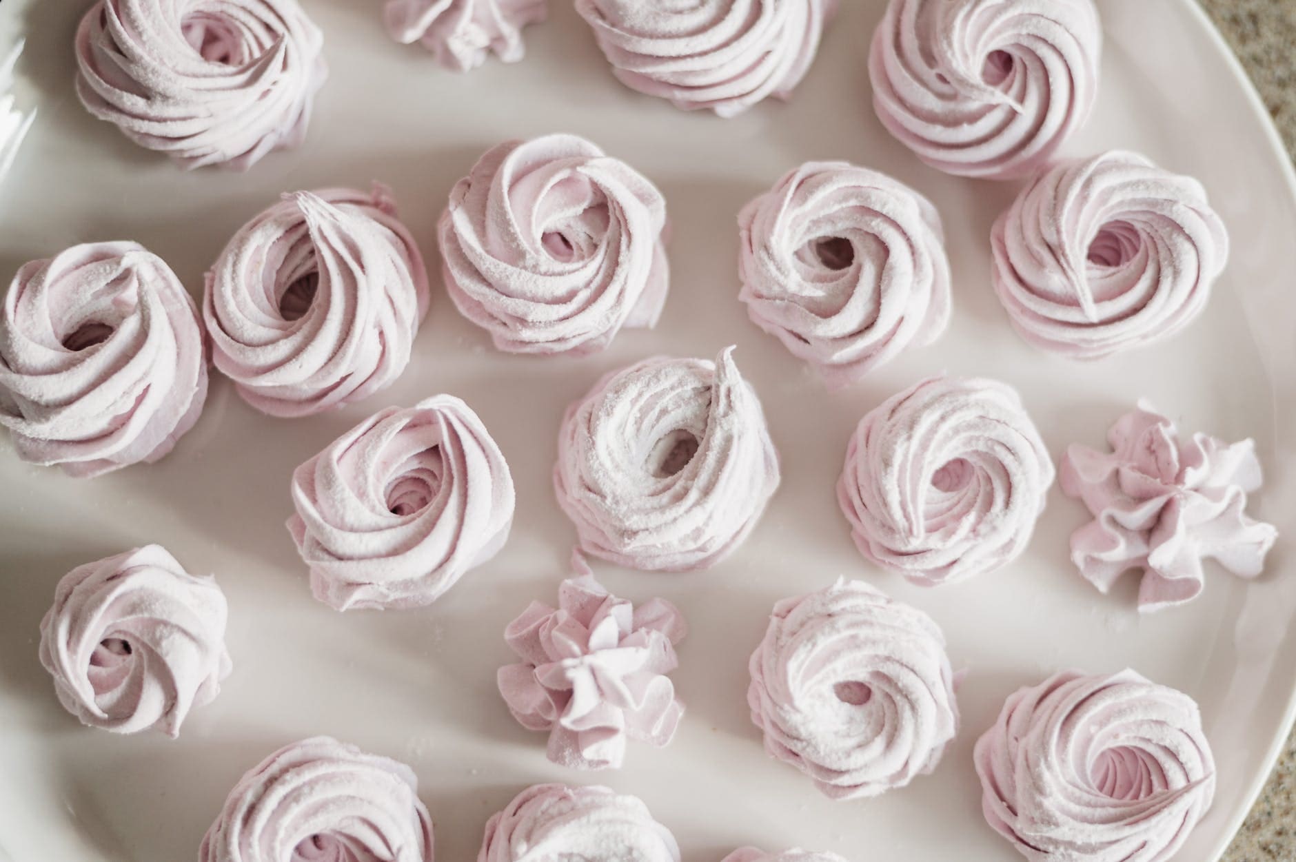 pink meringues on a white plate from this meringue recipe