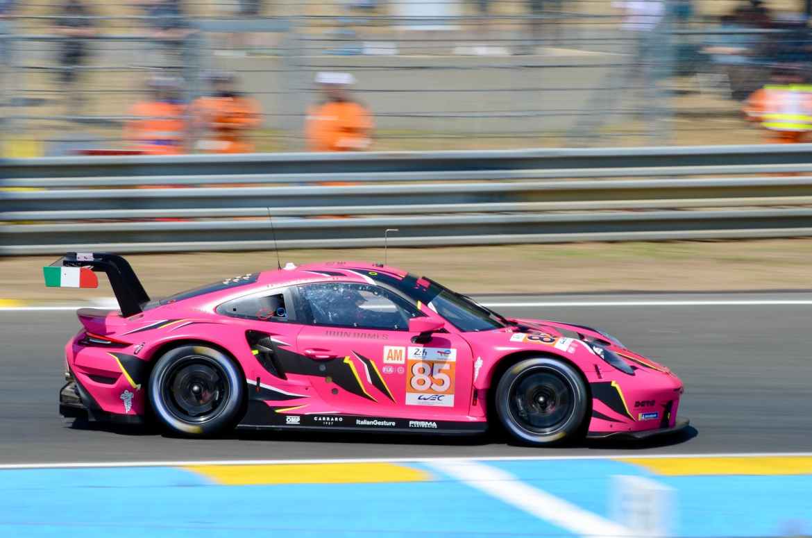 a pink porsche racing car on a race track