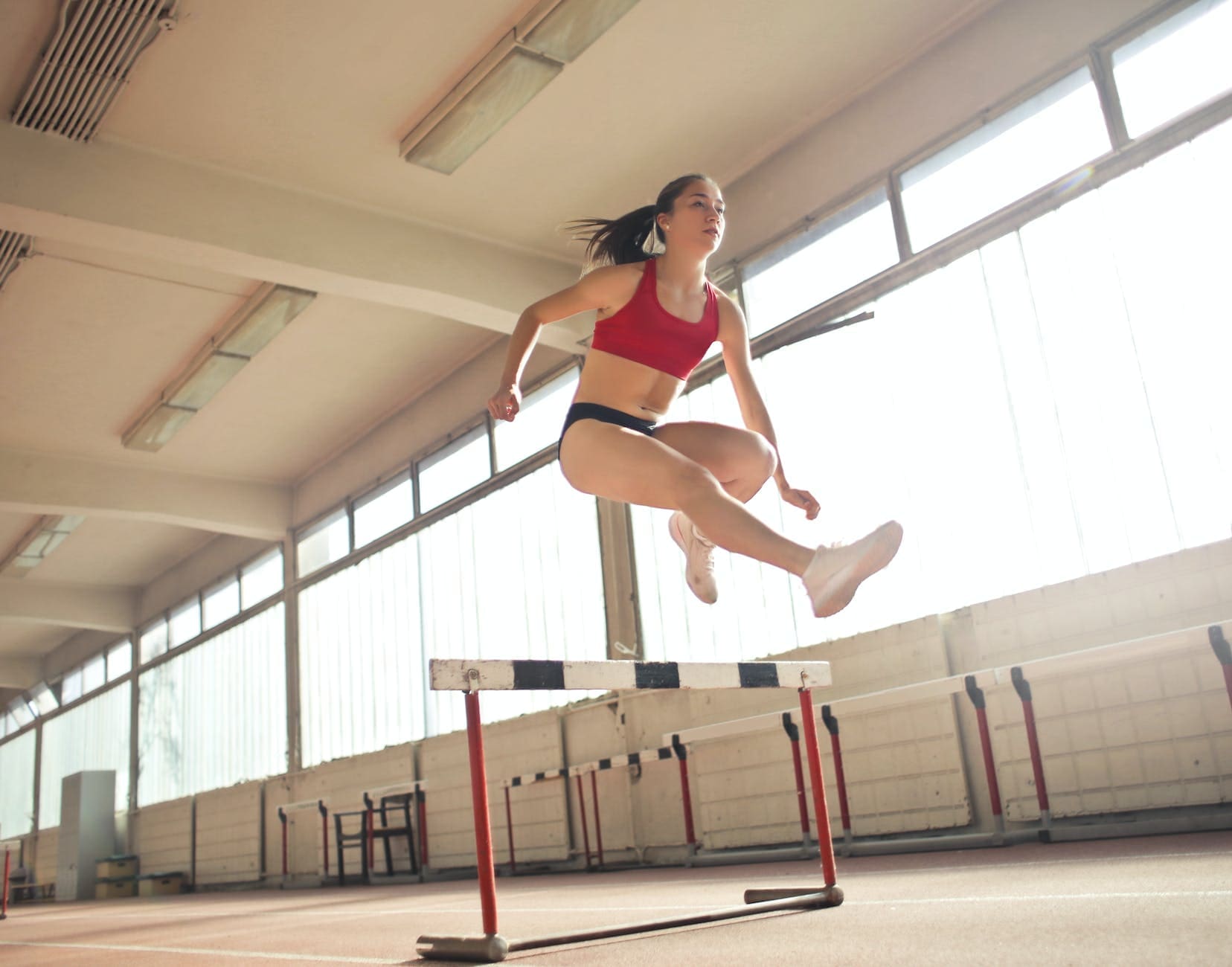 photo of a woman jumped on obstacle as a way to Set goals example